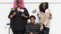 Three women holding pride flags.